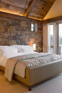 a bedroom with stone wall accent