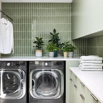 A laundry room with green tiles 