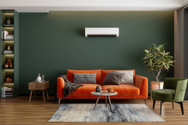 A living room with orange couch and green accents 