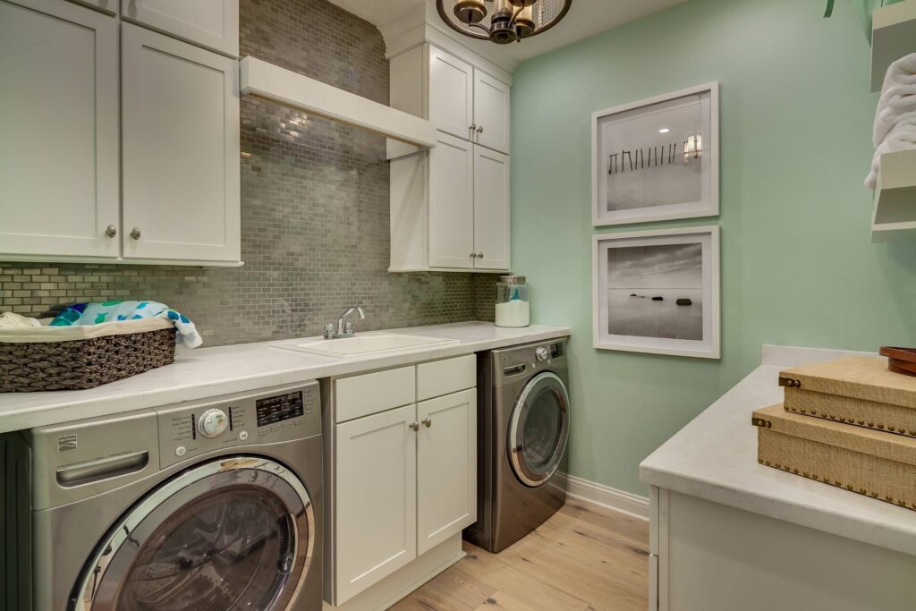 A laundry room painted with sage green coloured walls 