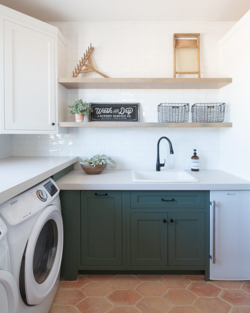 A laundry room with two tone cabinets 