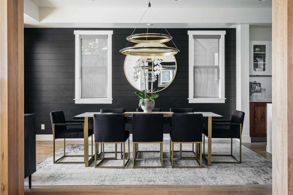 A dining room with black panel walls 