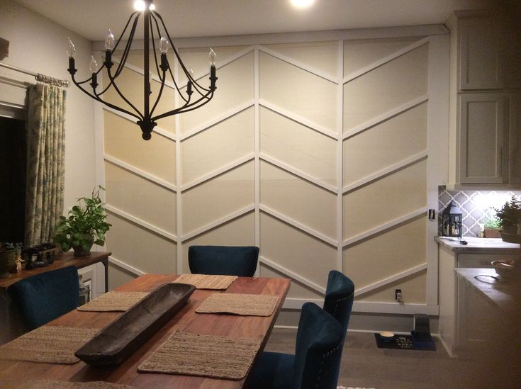 A dining room with chevron pattern  wall molding