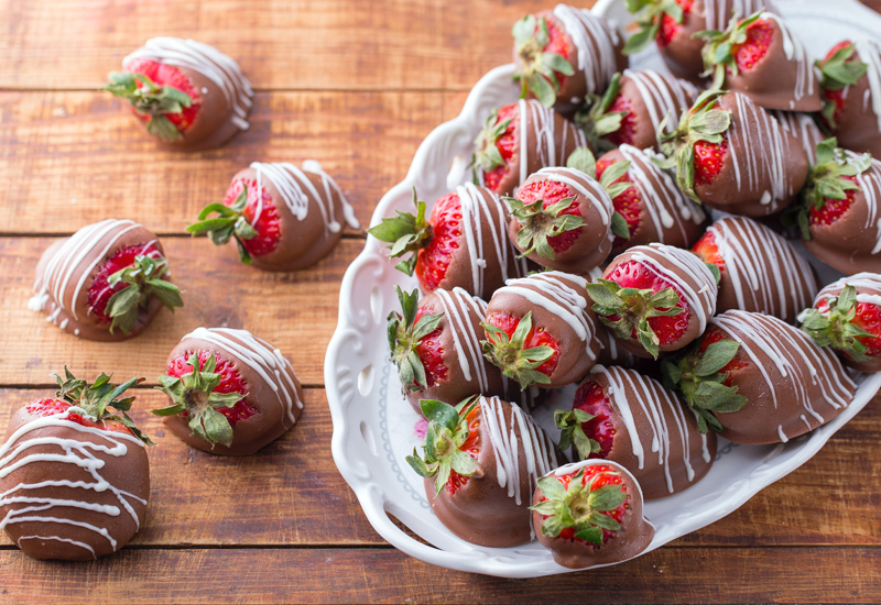 A hotel room with chocolate-covered strawberries 