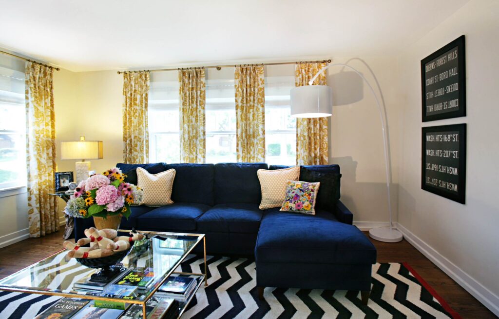 A living room with dark shaded furnitures and colorful accessories 