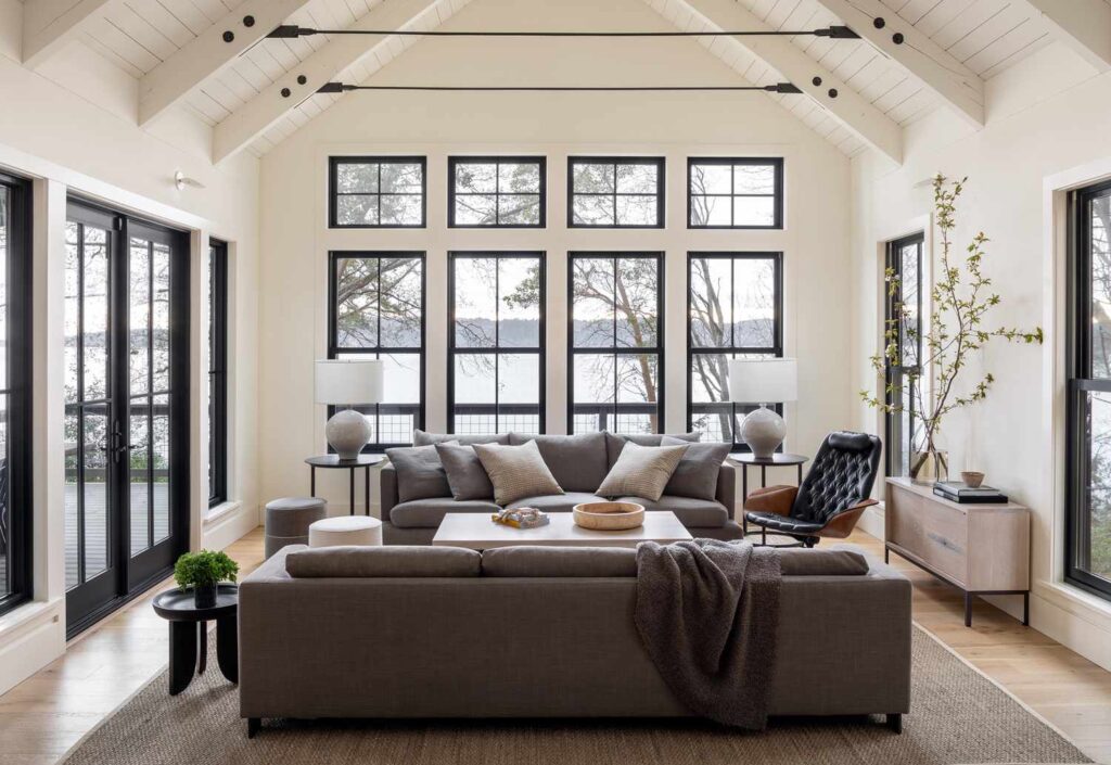 A living room with dark furnitures and transparent-glass windows 