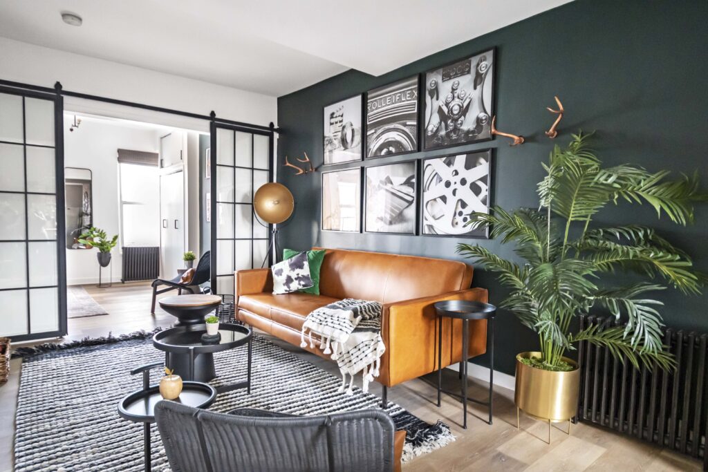 A living room with dark furnitures and greenery 