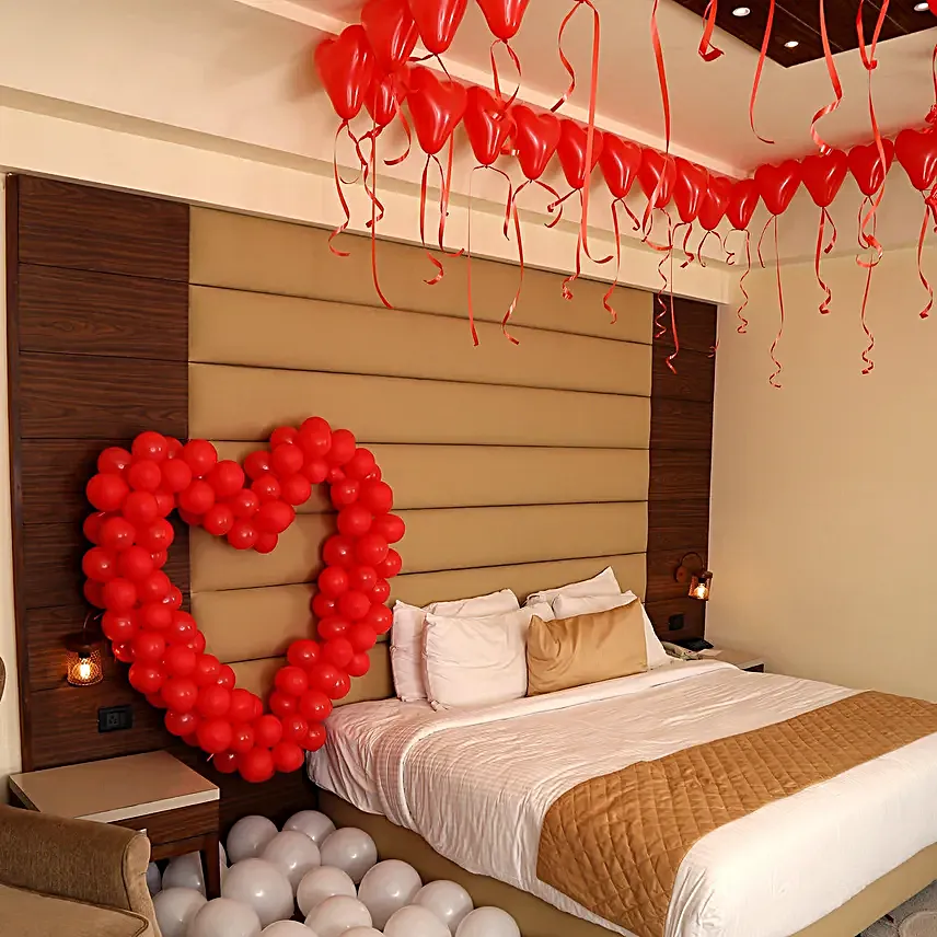 A hotel room with heart shaped balloons 