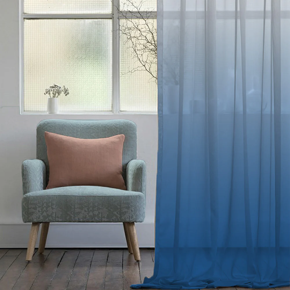 A living room with ombre sheer curtains 