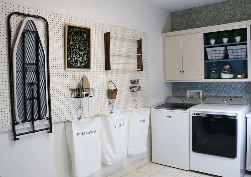 A laundry room with pegboard art 