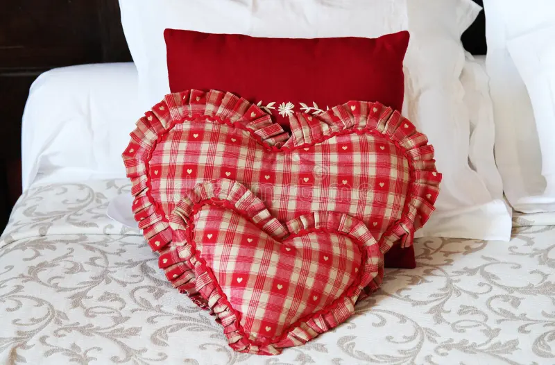 A hotel room with cozy blanket and pillows 