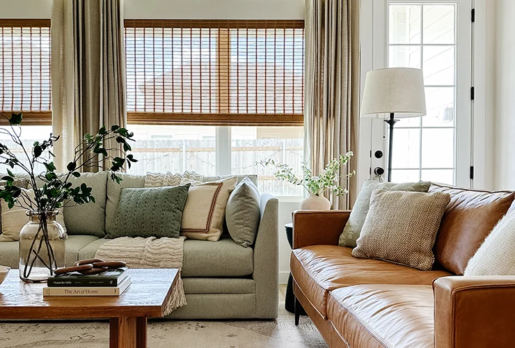 A living room with roman shaded sheer curtains 