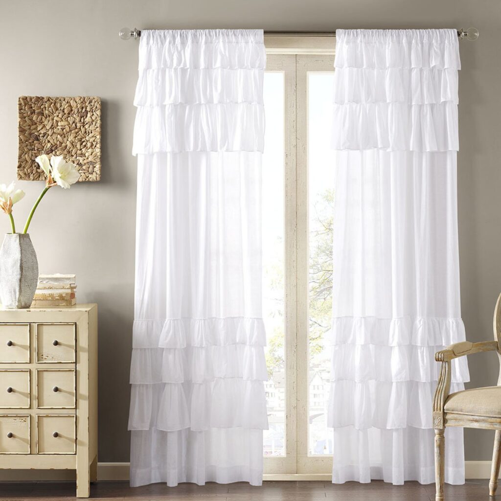 A living room with sheer curtains with ruffles 