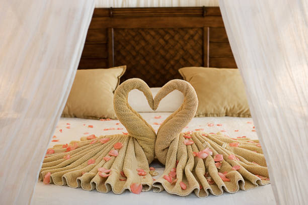 A hotel room with towels arranged in heart shape 