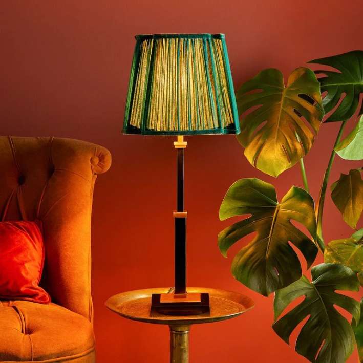Green lamp on a side table and burnt orange walls
