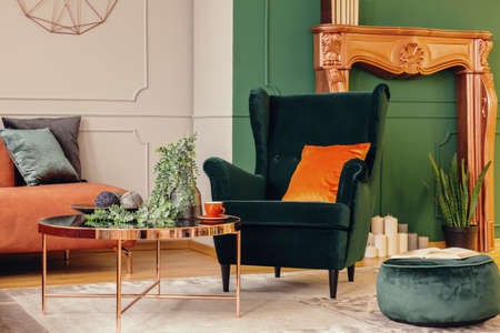 Velvet green armchair with burnt orange pillows