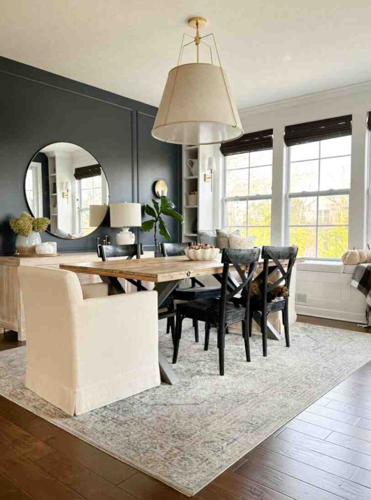 A cream rug under the dining table with linen chair and a ceiling cream color lamp