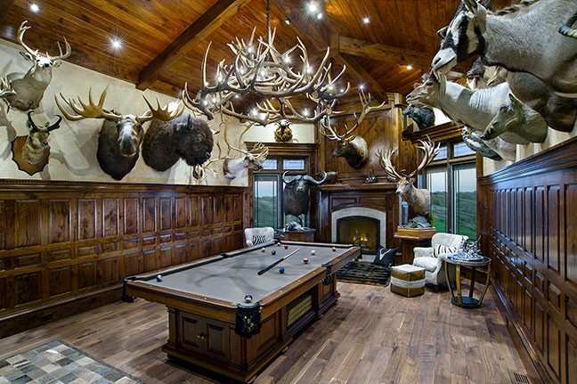 A wooden billiard table in the middle of the hunting room