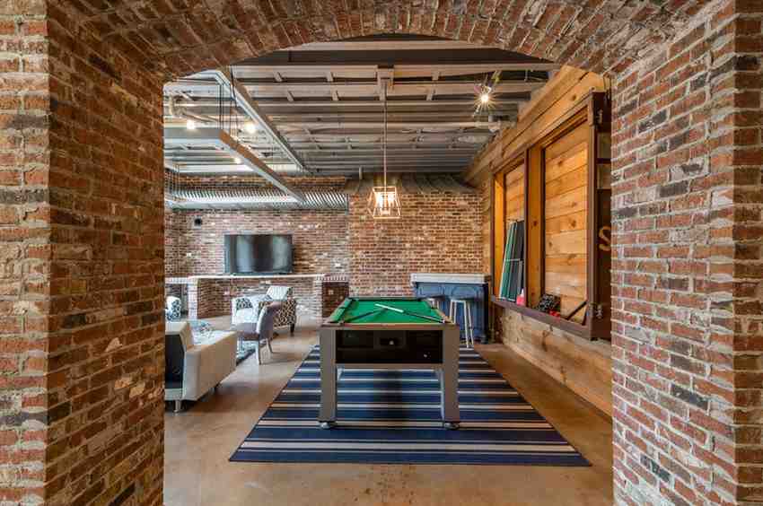 Red brick walls around the room and steel grey color ceiling with wooden wall built-in