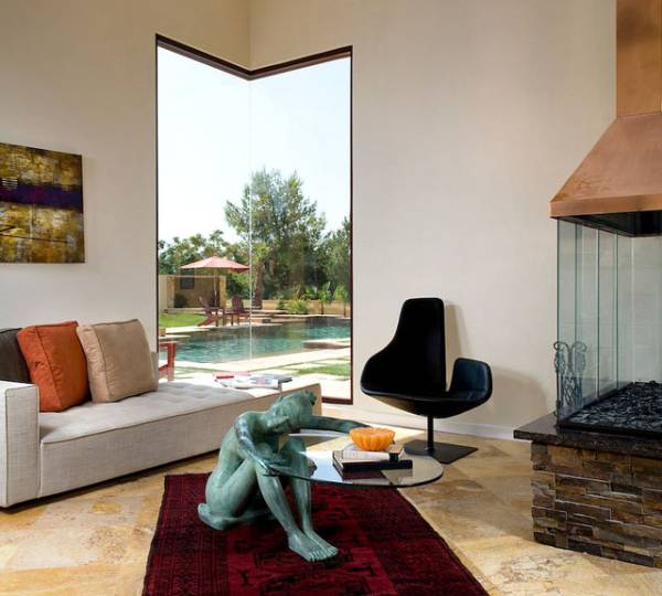 Corner picture window in a living room viewing outside pool