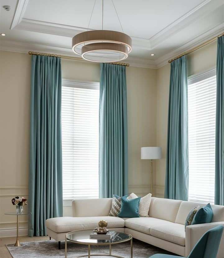 Floor to ceiling teal turquoise curtains against cream wall and sofa