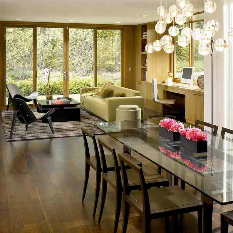 Chair and glass top dining table and a yellow color sofa in open layout living room