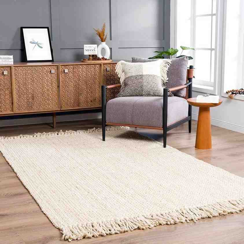 Rattan beige rug and a wooden side table with a black and grey armchair