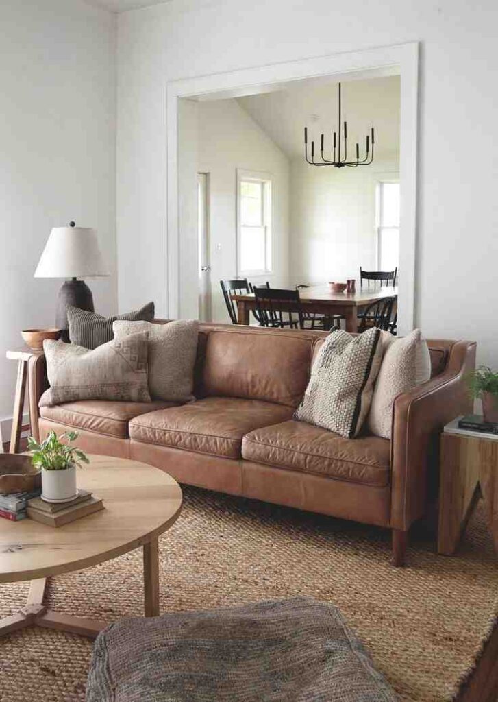 Brown leather sofa against a white wall on a jute beige rug