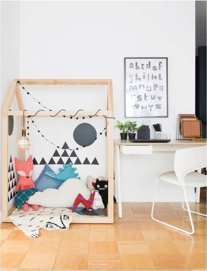 Wooden home shaped frame in the corner of the room for play zone