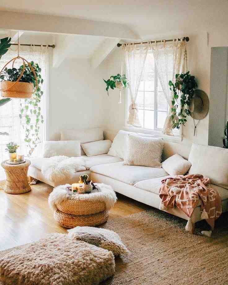 Some wall hanging plants and a white sofa with a jute center coffee table