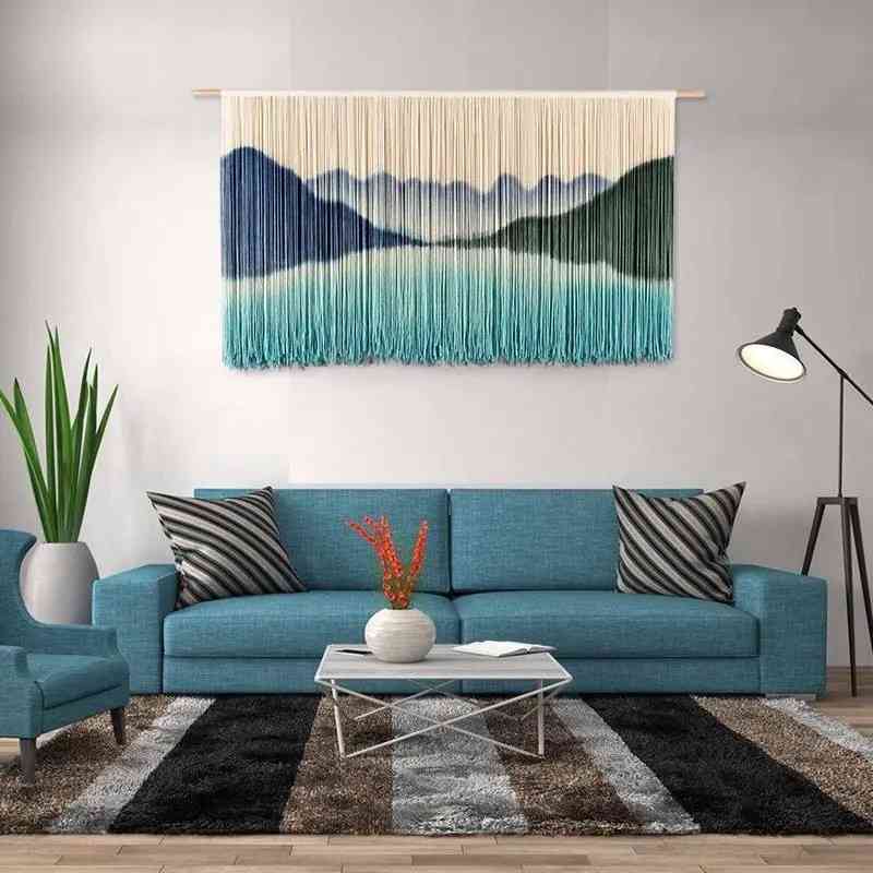 A teal turquoise macrame hanging on a wall above sofa