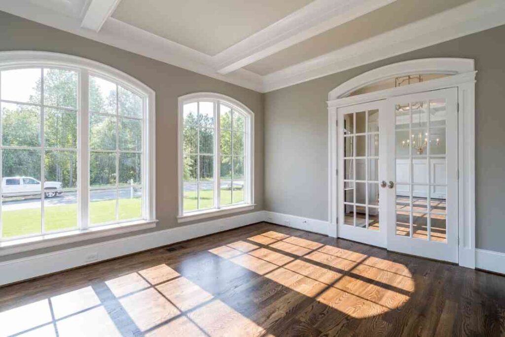 Arched white picture window's and wooden flooring for living room