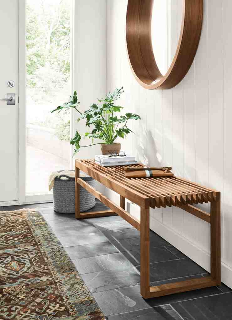 Wooden bench with a pot placed on it and a mirror hanged above it