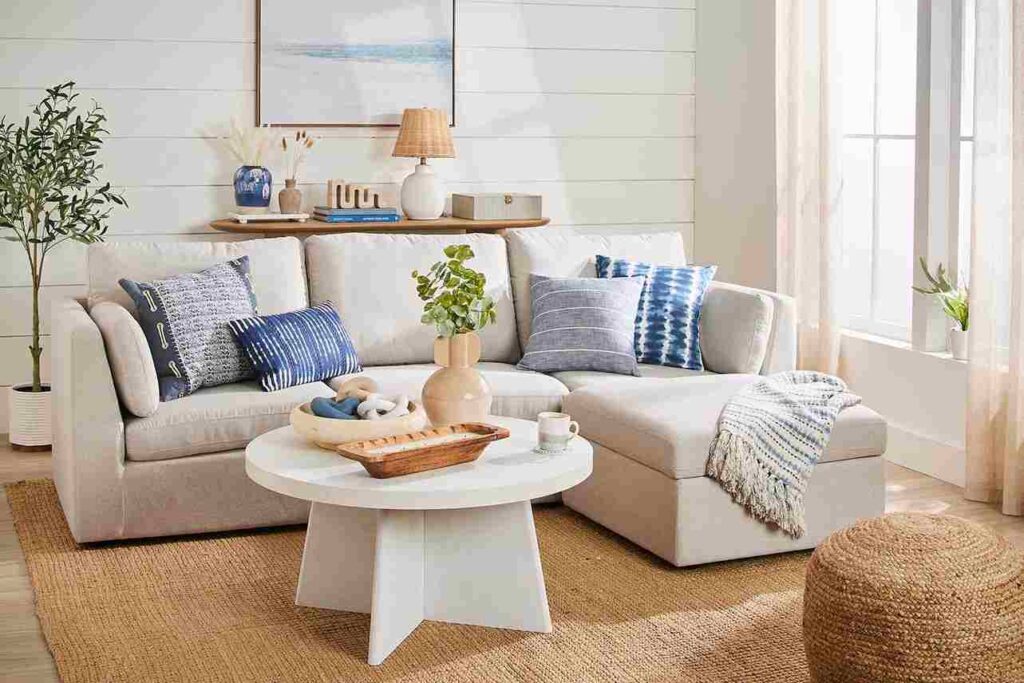 A coffee table and a sofa in white color and blue textured pillow on it