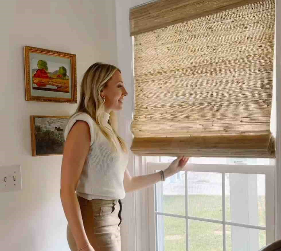 A girl closing the bamboo curtains in laundry room
