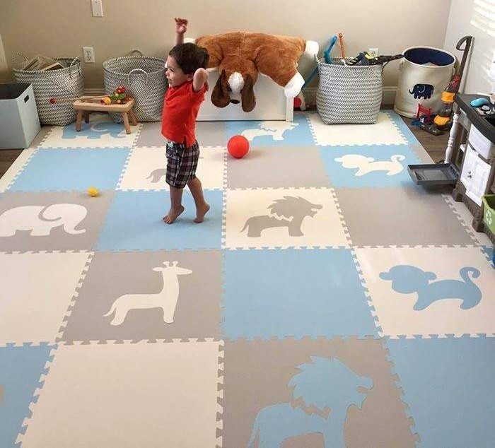 Kid standing on blue, gray, and white foam lay mats