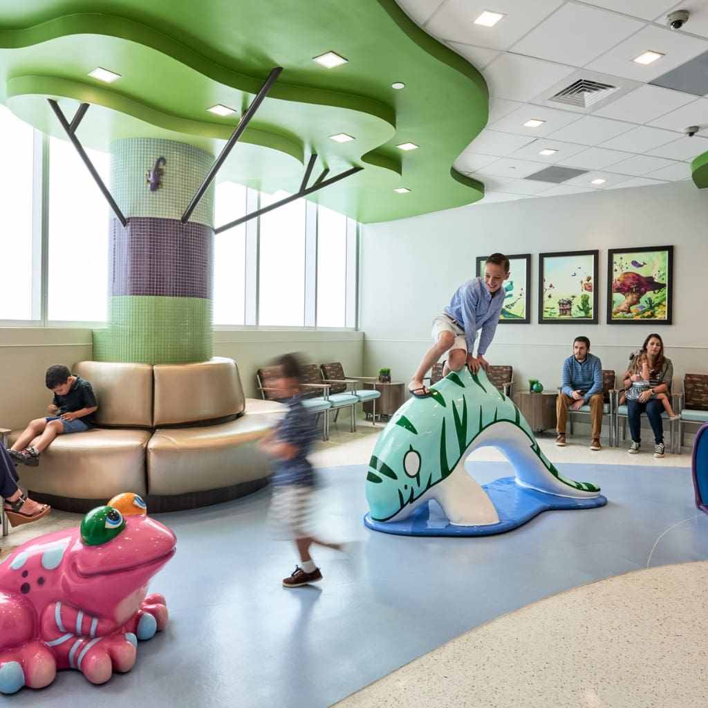 A-kid-playing-on-a-dolphin-statue-and-a-kid-seating-aside-on-sofa