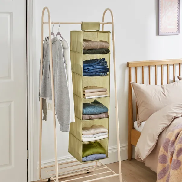 An open metal wardrobe and a green hanging organizer for clothes