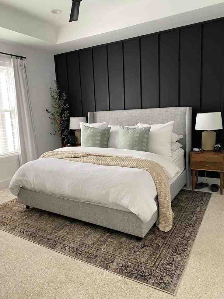 Black French wall panelling and a boho rug under the bed