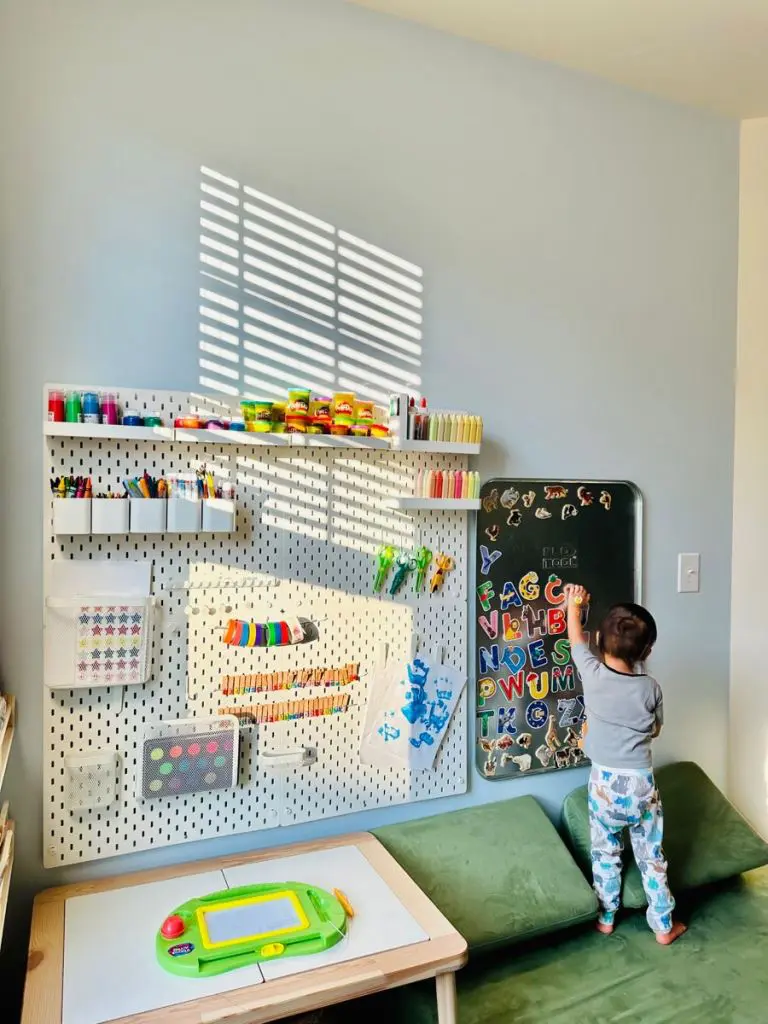 White wall and a pegboard with a black board on wall