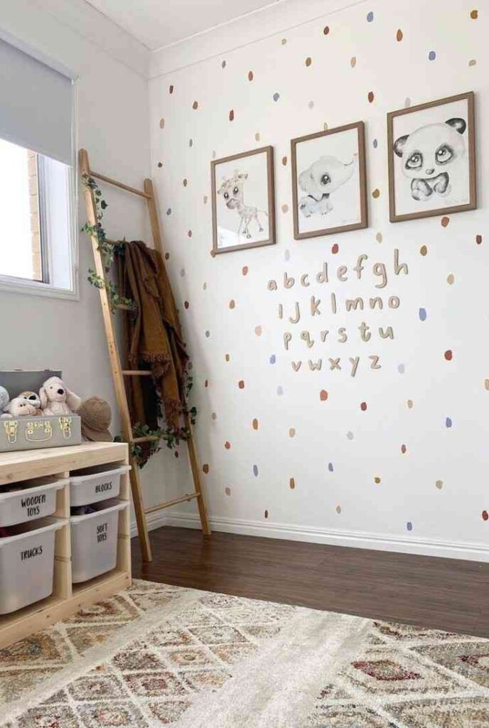 White wall with alphabet character on it and three cartoon art frames hanging on it 