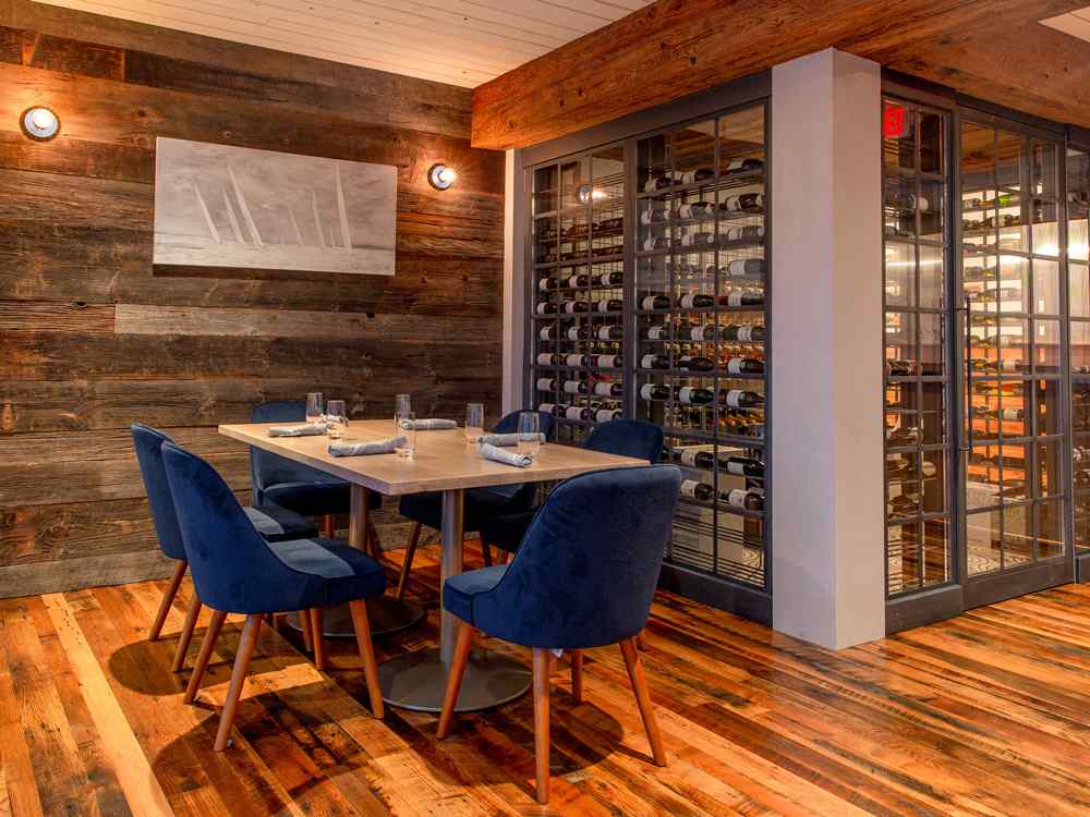 Wooden wall panelling and a wine room with a dining table