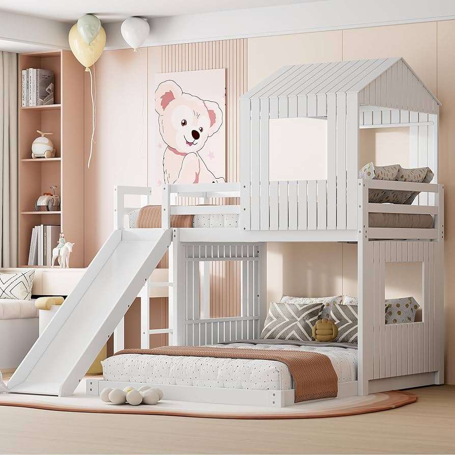 A white wooden bunk bed with slide and pink wall behind it