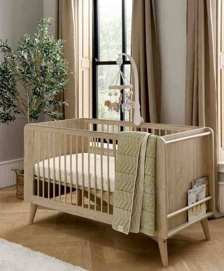 A wooden high sided crib and a side space to storage book and magazine