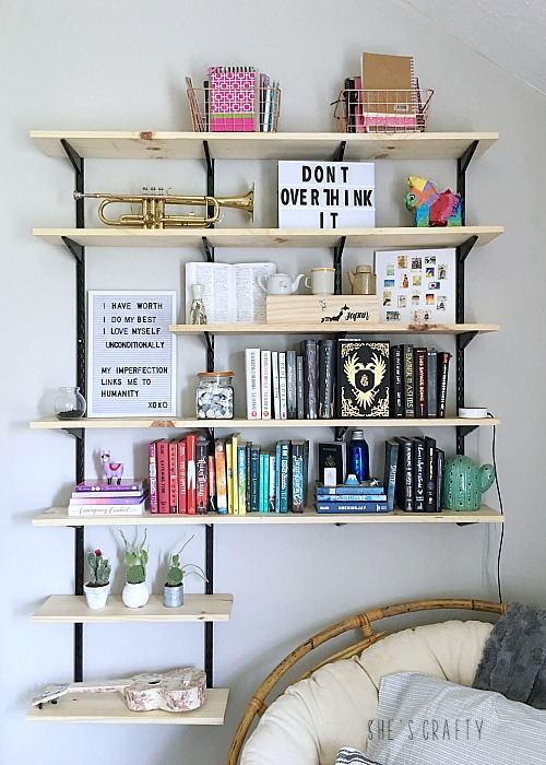 Black and white wooden and metal floating shelves and book on them