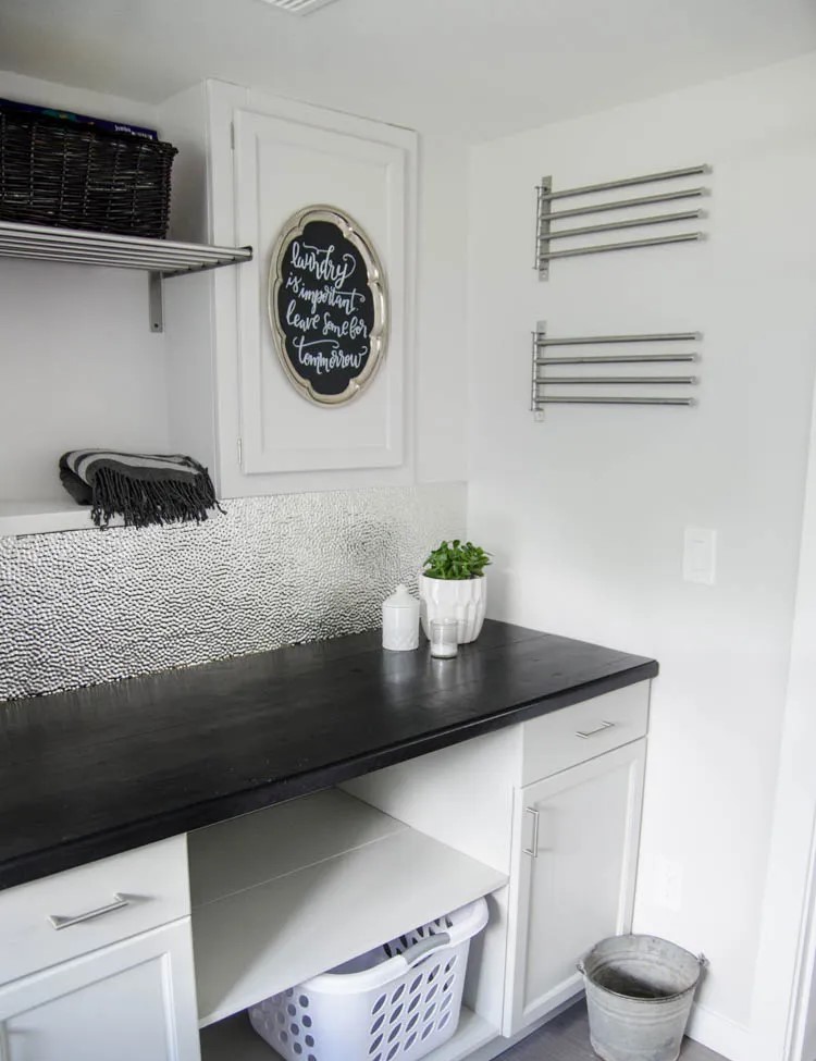 Wooden black counter to and white cabinet for the laundry room