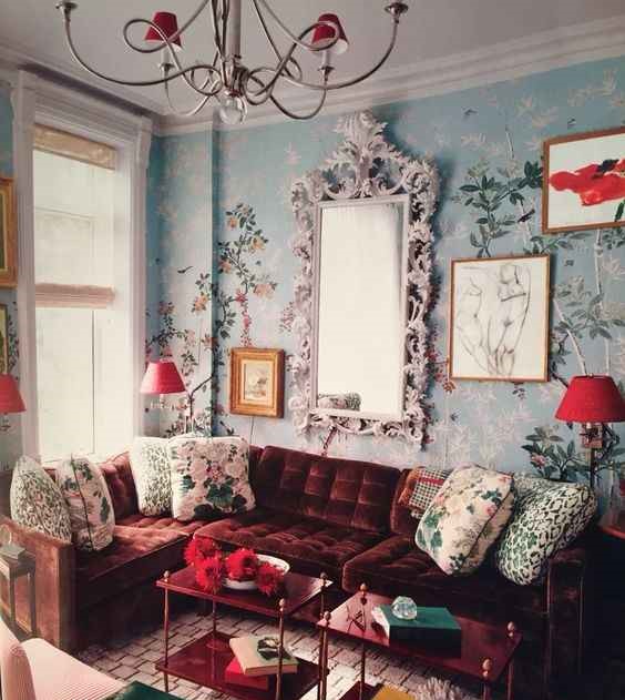 Blue wall and burgundy sofa with mirror behind it on wall