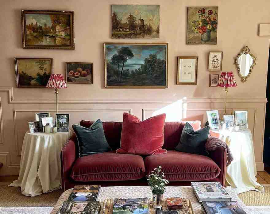 White side table and pink wall with a burgundy sofa