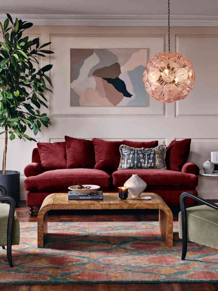 Burgundy sofa with a golden ceiling lamp and a wooden table