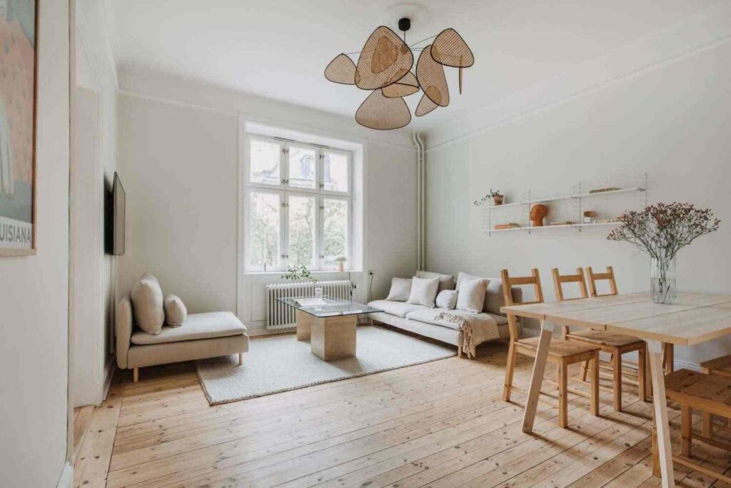 A wooden dining table and a ceiling lamp and a low flooring sofa 